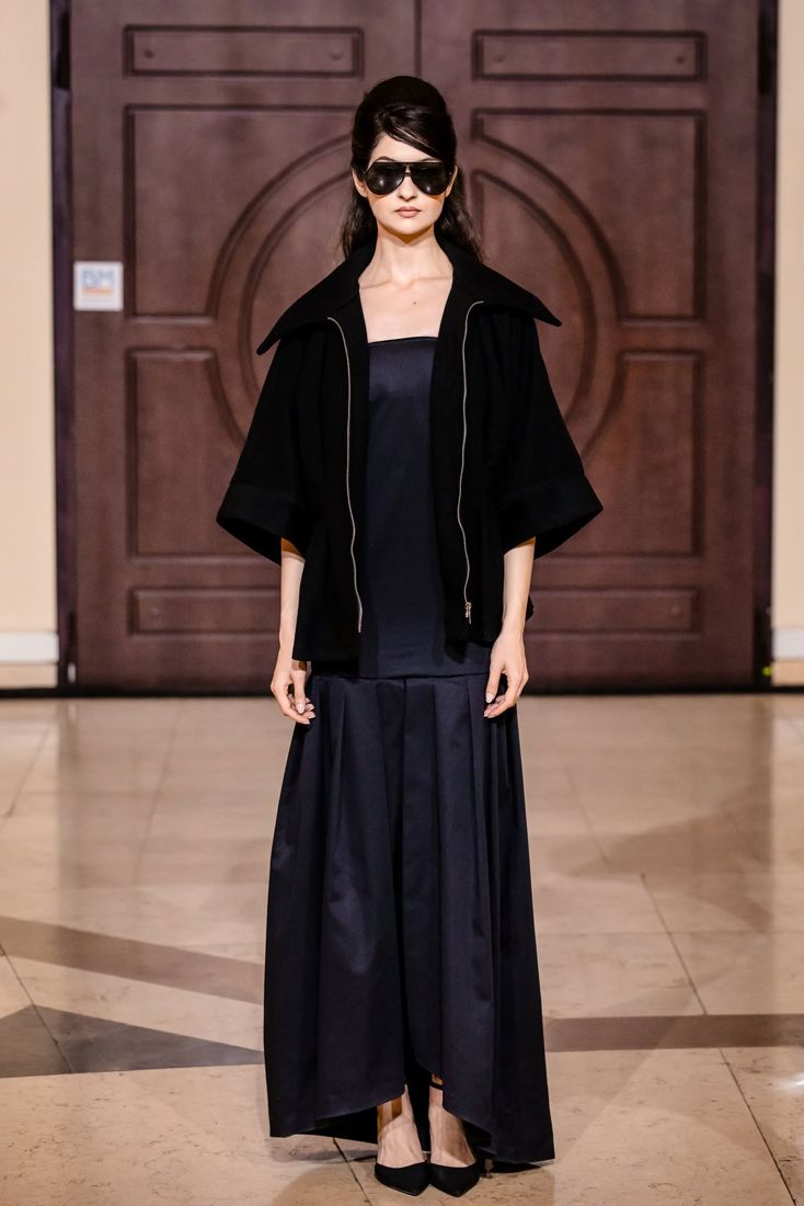 Look 17: Black wide-sleeve jacket, navy satin column skirt, shield shades