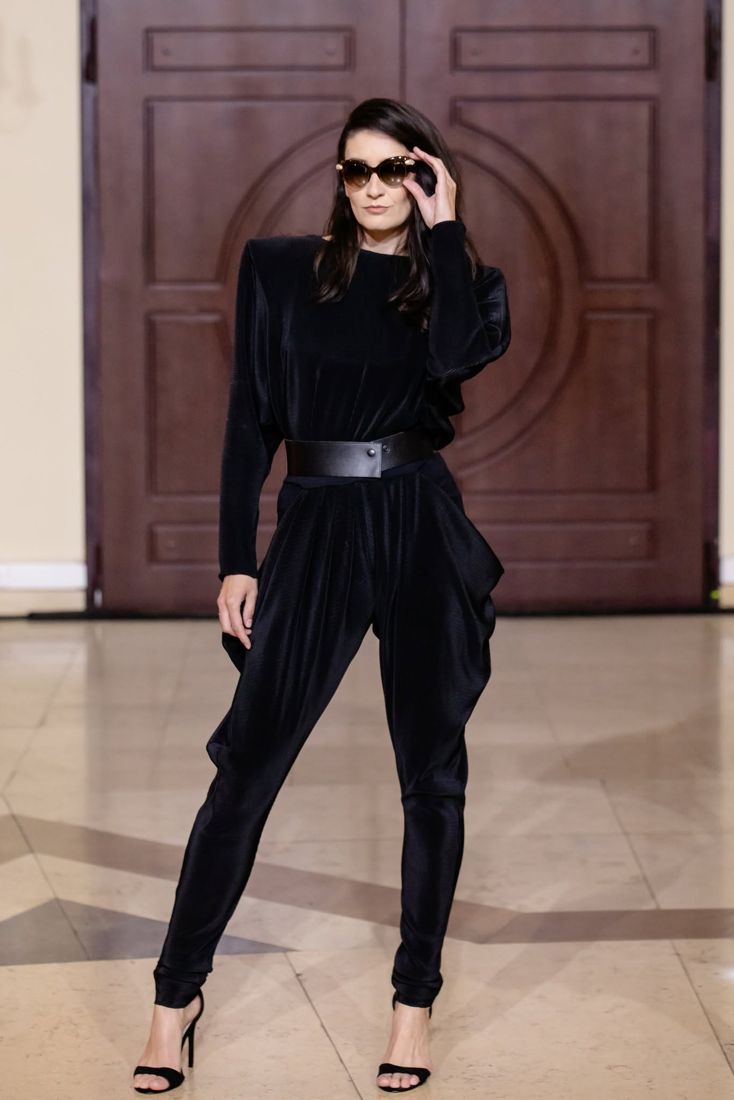 Look 24: Black pleated jumpsuit, strong shoulders, wide leather belt